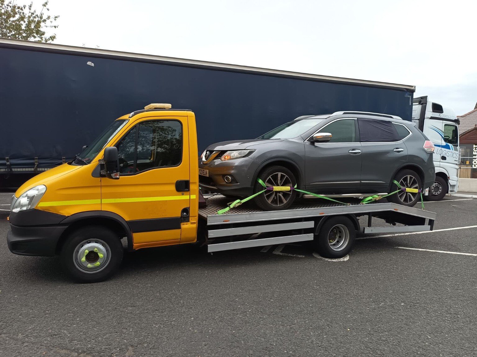 Yellow Workhorse Recovery truck transporting a grey Nissan SUV